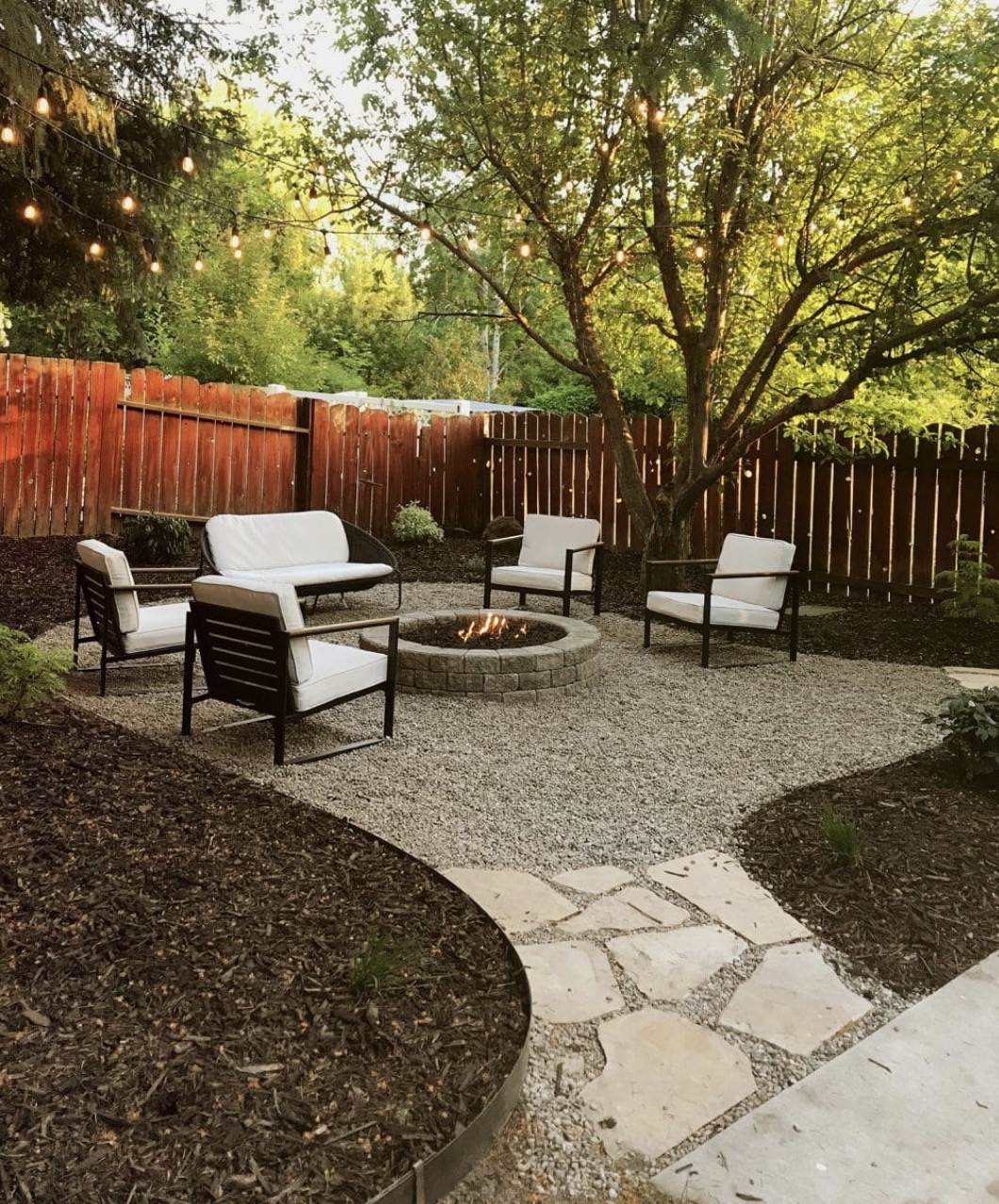Finished backyard renovation with a gravel seating area and fire pit